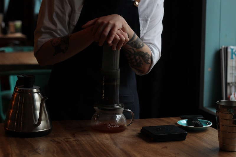 Barista brewing coffee with aeropress