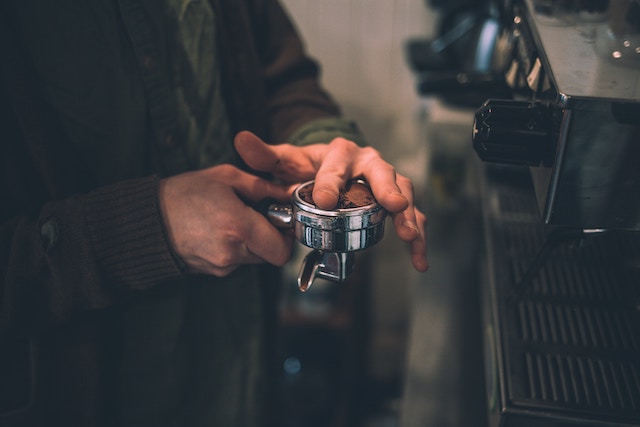 man leveling off portafilter with finger